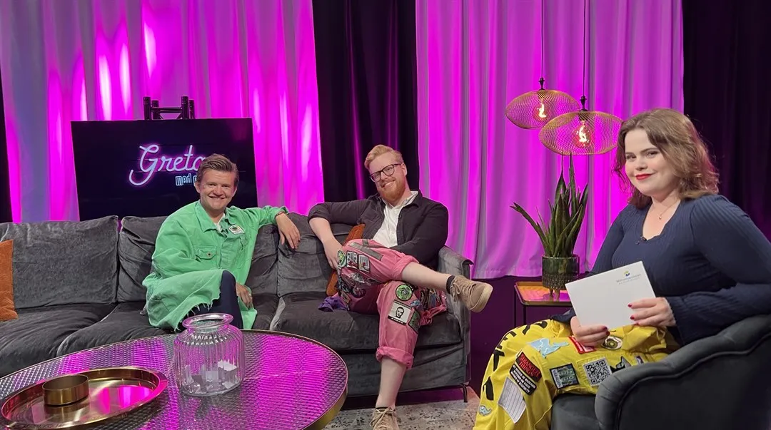 Tre personer sitter i en studio och tittar mot kameran.